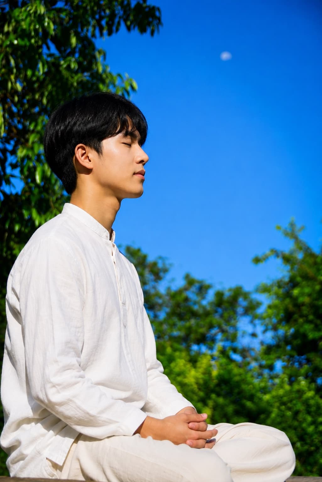 A young Ananda Marga practitioner meditating outdoors in Korea